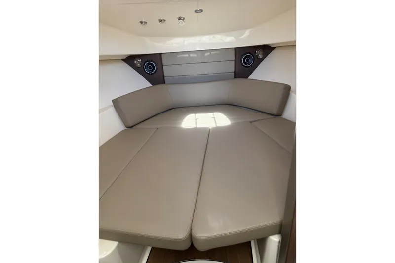 Slide: The Image of 2019 Boston Whaler 315 Conquest cabin interior with beige seating and modern design. - 14