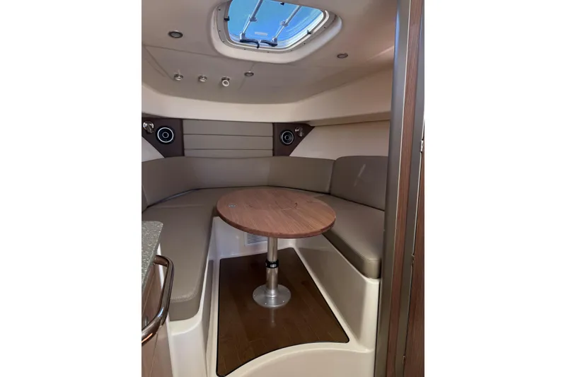 Slide: The Image of 2019 Boston Whaler 315 Conquest cabin interior with round table and seating. - 15