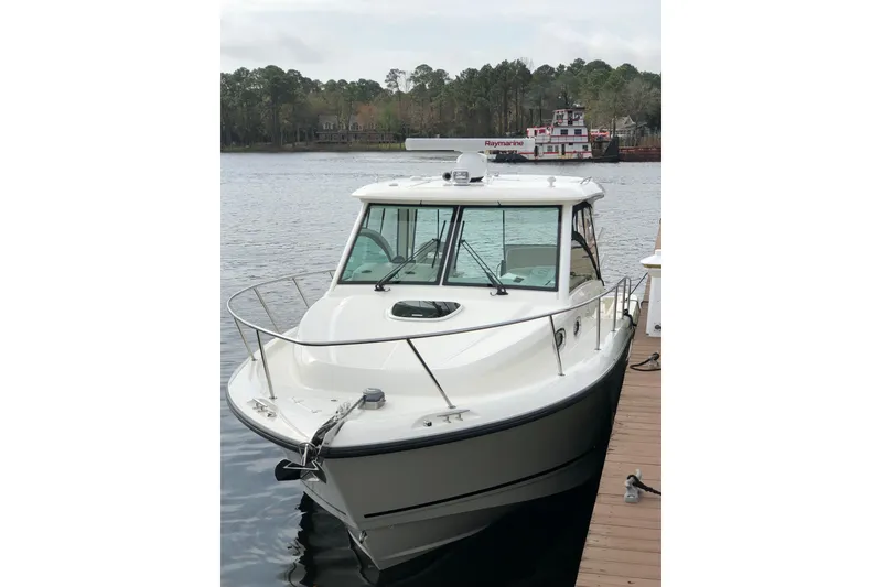 Slide: The Image of 2019 Boston Whaler 315 Conquest docked on a calm lake. - 6