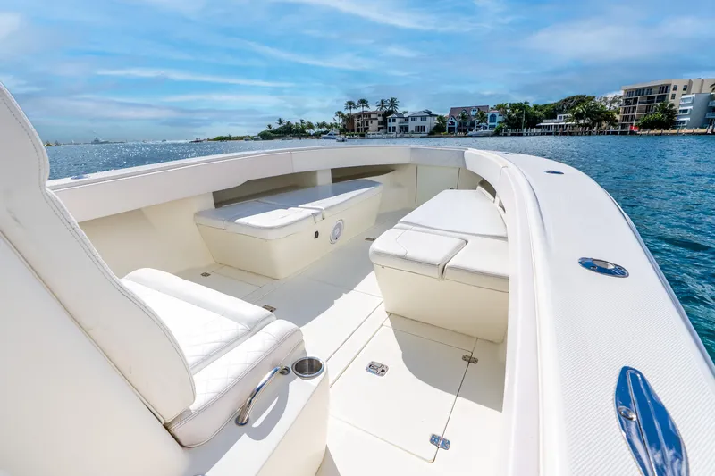 Slide: The Image of 2016 SeaVee 340Z boat interior with white seating, on a sunny waterfront. - 19