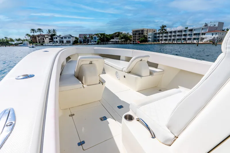 Slide: The Image of 2016 SeaVee 340Z boat interior with white seating, docked near waterfront homes. - 21