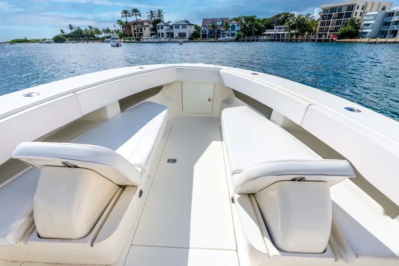 Slide: The Image of 2016 SeaVee 340Z boat interior with white seating, overlooking waterfront homes. - 22