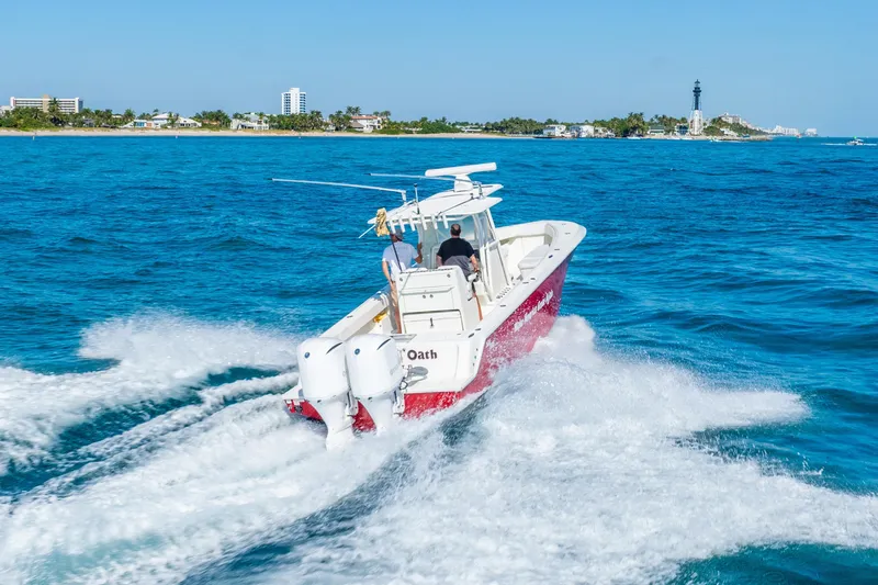 Slide: The Image of 2016 SeaVee 340Z boat cruising on blue ocean near coastal buildings. - 56