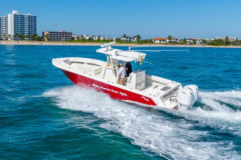 Slide: The Image of 2016 SeaVee 340Z boat cruising on blue ocean near coastal buildings. - 57