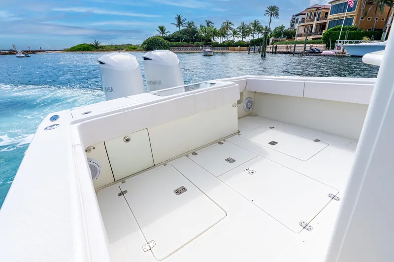 Slide: The Image of 2016 SeaVee 340Z boat deck with Yamaha engines, docked near luxury waterfront homes. - 6