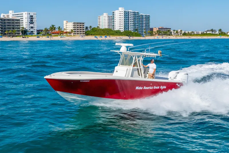 Slide: The Image of 2016 SeaVee 340Z boat cruising near a beach with buildings in the background. - 60