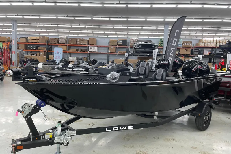 Slide: The Image of 2026 Lowe Fishing Machine 1675SC boat displayed in showroom, featuring sleek black design. - 4