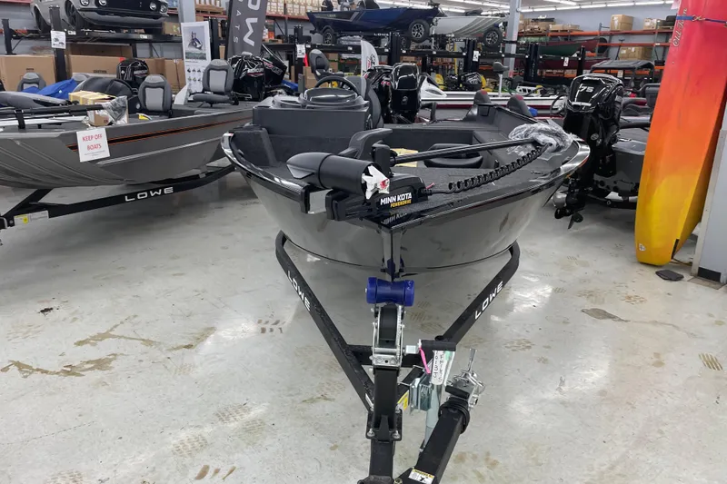 Slide: The Image of 2026 Lowe Fishing Machine 1675SC displayed in a showroom with other boats. - 5