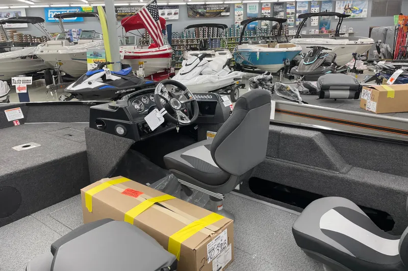 Slide: The Image of 2026 Lowe Fishing Machine 1675SC in showroom with various boats and equipment. - 6
