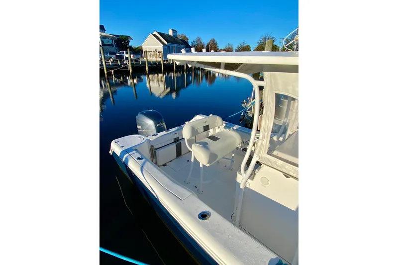 Slide: The Image of 2013 Tidewater 230 CC Adventure boat docked on calm water, clear blue sky. - 4
