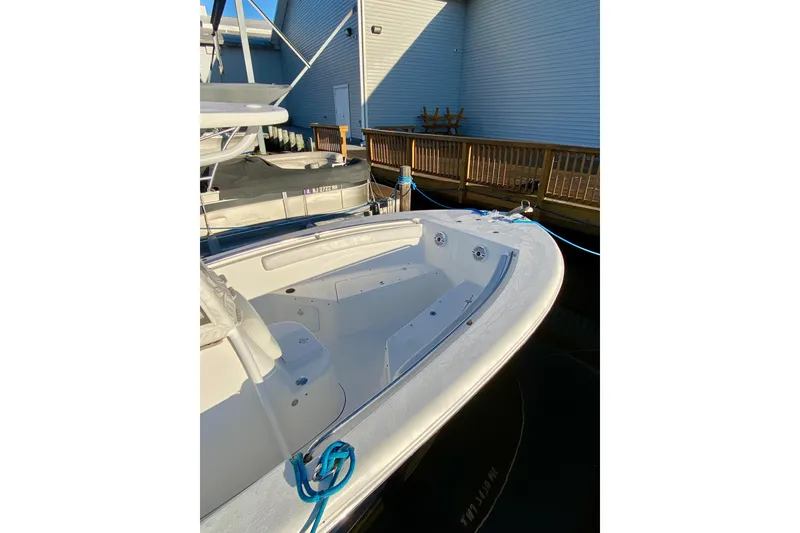 Slide: The Image of 2013 Tidewater 230 CC Adventure boat docked, showcasing spacious deck and sleek design. - 5