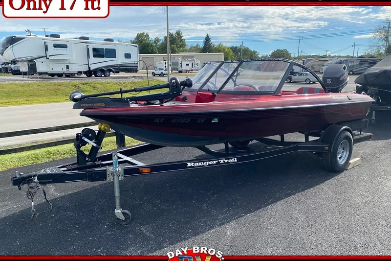 Slide: The Image of 1999 Ranger R77 Sport boat on trailer, red color, parked outdoors, 17 feet long. - 1