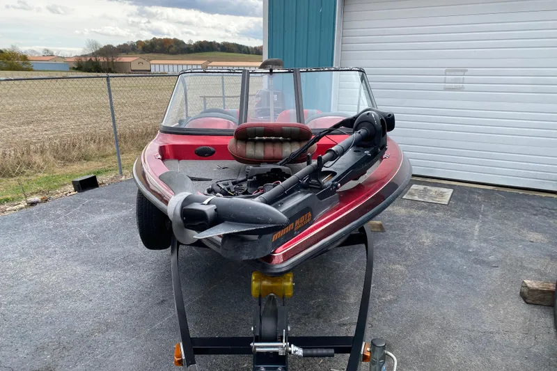 Slide: The Image of 1999 Ranger R77 Sport boat on trailer, parked near a garage. - 10