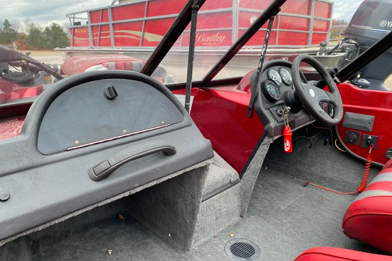 Slide: The Image of 1999 Ranger R77 Sport boat interior with steering wheel and dashboard controls. - 15