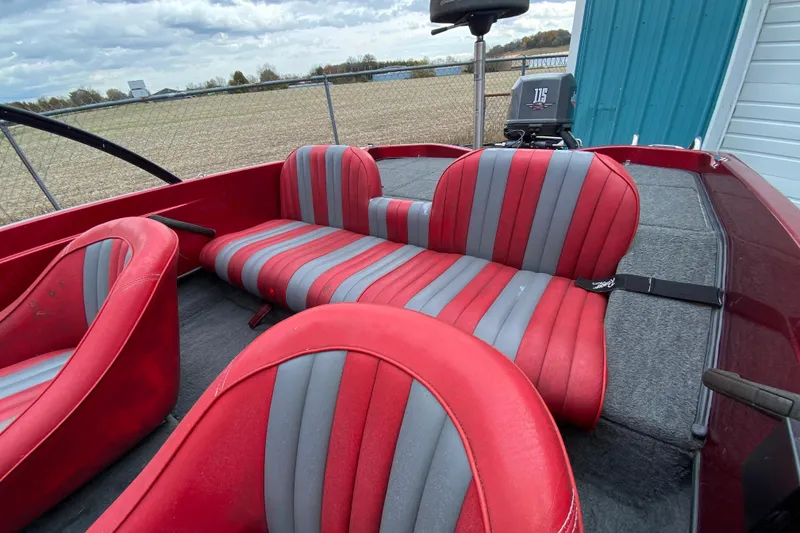 Slide: The Image of 1999 Ranger R77 Sport boat interior with red and gray striped seats. - 17
