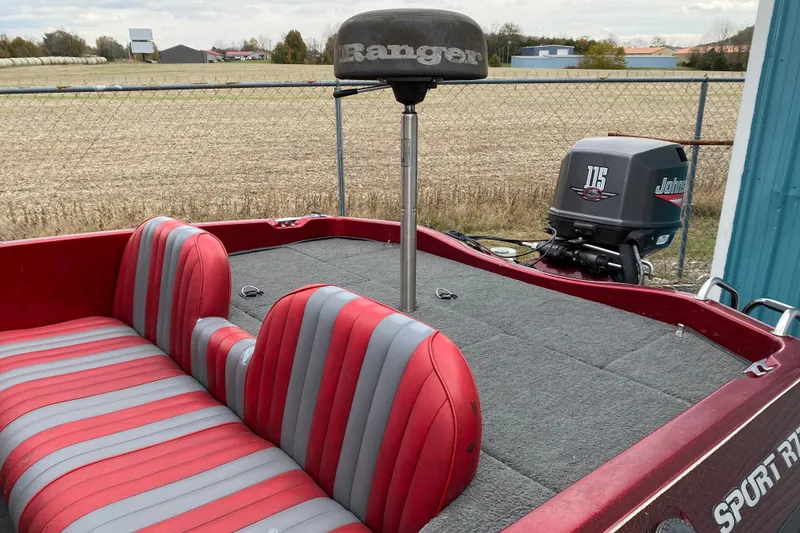 Slide: The Image of 1999 Ranger R77 Sport boat with red and gray seats, Johnson 115 outboard motor. - 18