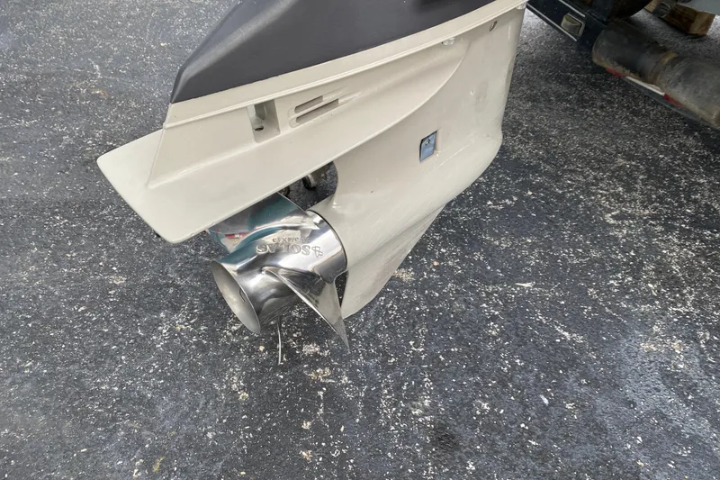 Slide: The Image of 1999 Ranger R77 Sport boat motor with stainless steel propeller on asphalt. - 20