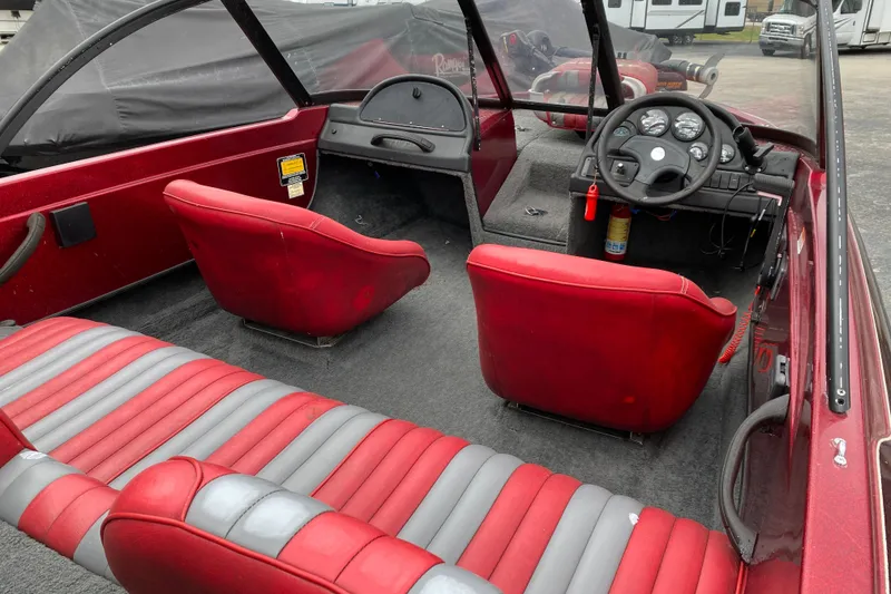 Slide: The Image of 1999 Ranger R77 Sport boat interior with red and gray seating, steering console, and dashboard. - 22