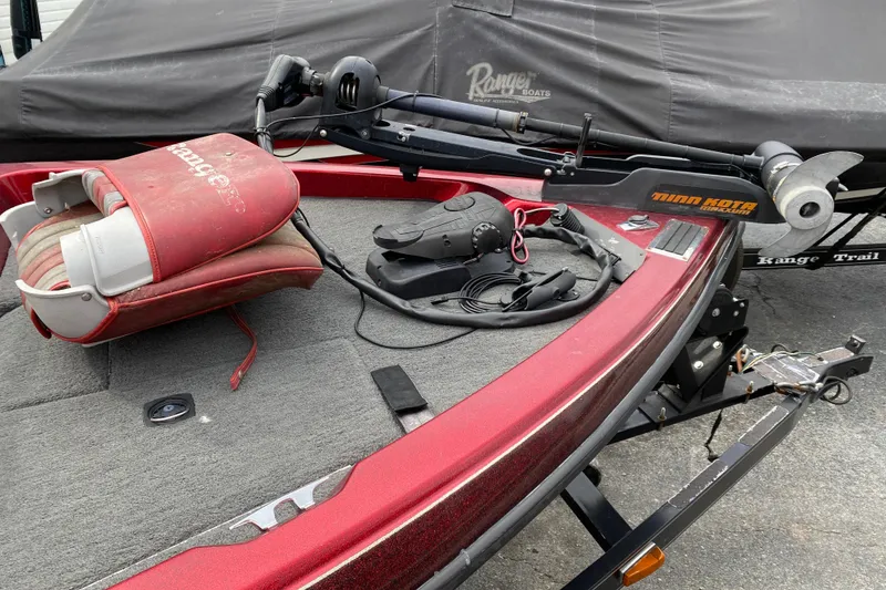 Slide: The Image of 1999 Ranger R77 Sport boat with Minn Kota trolling motor and red seat on deck. - 24