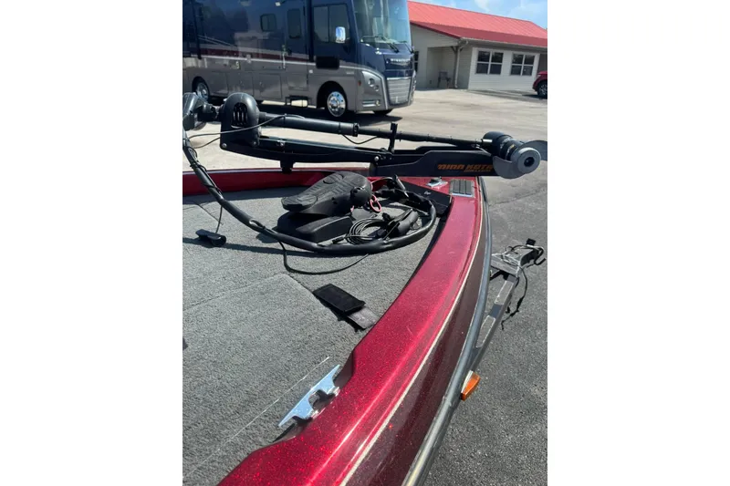 Slide: The Image of Red 1999 Ranger R77 Sport boat with trolling motor, parked near RV. - 26