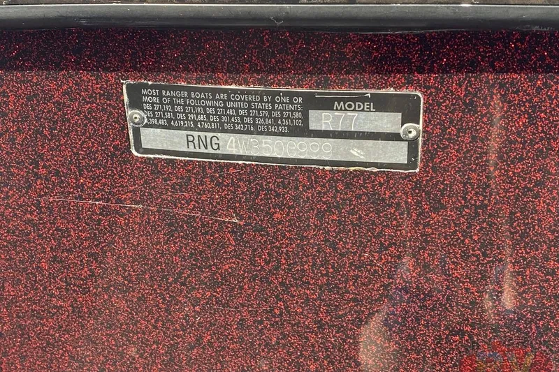 Slide: The Image of 1999 Ranger R77 Sport boat identification plate on a speckled red surface. - 30
