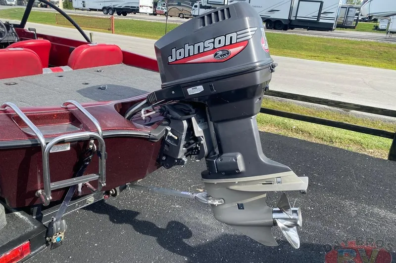 Slide: The Image of 1999 Ranger R77 Sport boat with Johnson outboard motor, parked outdoors. - 5