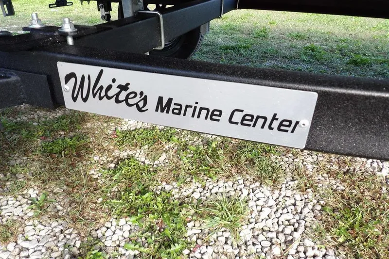 Slide: The Image of Trailer hitch with "White's Marine Center" sign on gravel and grass. - 19