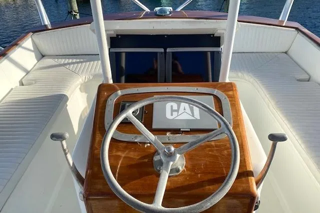 Slide: The Image of 1988 Buddy Davis 47 Custom Carolina boat helm with wooden steering wheel and CAT logo. - 11