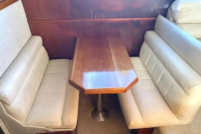 Slide: The Image of Interior of 1988 Buddy Davis 47 Custom Carolina with wooden table and cushioned seating. - 16