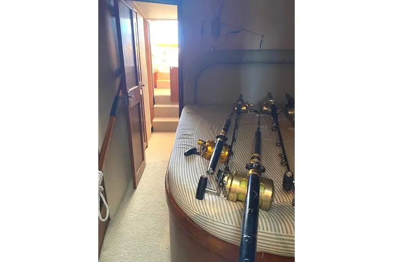 Slide: The Image of Interior of 1988 Buddy Davis 47 Custom Carolina with fishing rods on bed. - 26