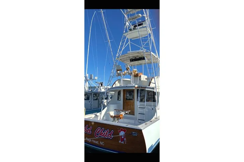 Slide: The Image of 1988 Buddy Davis 47 Custom Carolina boat with tall tower, docked under clear blue sky. - 5