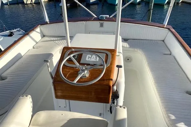 Slide: The Image of 1988 Buddy Davis 47 Custom Carolina boat helm with wooden steering wheel and white seating. - 6