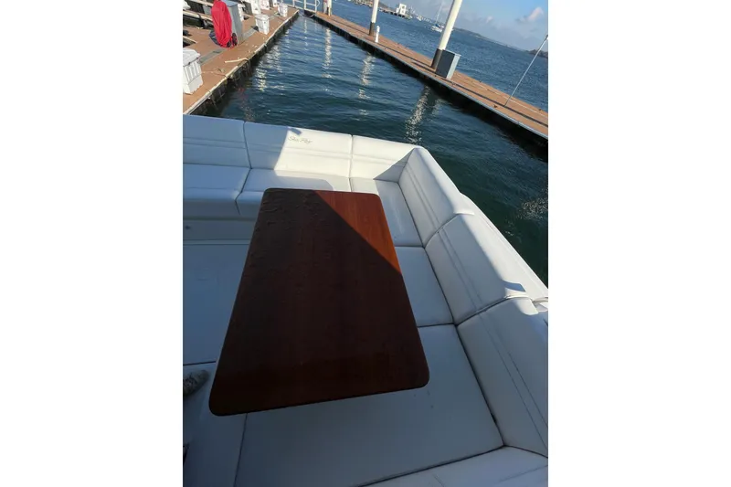 Slide: The Image of 2013 Sea Ray 510 Sundancer yacht with white seating and wooden table at dock. - 22