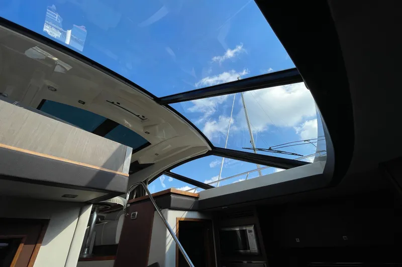 Slide: The Image of Interior view of 2013 Sea Ray 510 Sundancer yacht with open sunroof and blue sky. - 23