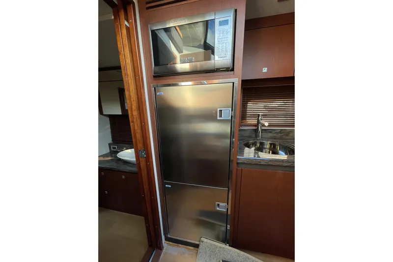 Slide: The Image of 2013 Sea Ray 510 Sundancer yacht kitchen with stainless steel fridge and microwave. - 30