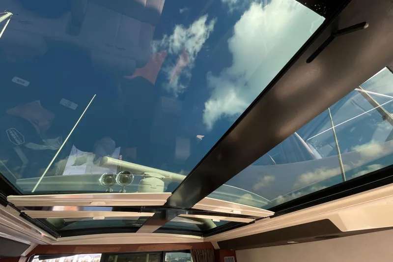 Slide: The Image of Glass sunroof view on 2013 Sea Ray 510 Sundancer yacht, showcasing blue sky and clouds. - 31