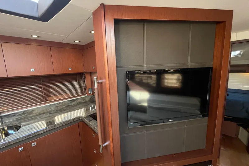 Slide: The Image of Luxurious interior of 2013 Sea Ray 510 Sundancer with modern kitchen and wall-mounted TV. - 48