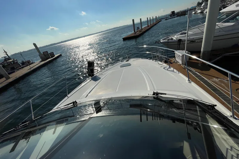 Slide: The Image of 2013 Sea Ray 510 Sundancer yacht docked, overlooking a sunlit marina. - 7