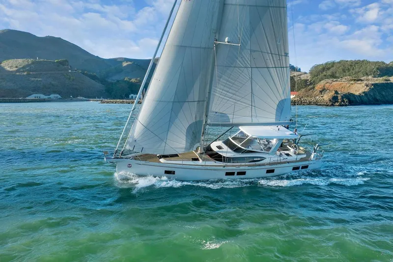 The Image of 2020 Hylas H57 yacht sailing in scenic coastal waters with mountainous backdrop. - 0