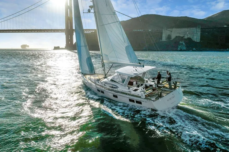 Slide: The Image of Sailing yacht Hylas H57, 2020 model, cruising near a large bridge on a sunny day. - 2