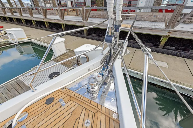 Slide: The Image of 2020 Hylas H57 yacht deck with polished fittings and wooden flooring at a marina. - 46