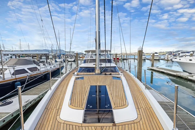 Slide: The Image of 2020 Hylas H57 yacht docked in marina, showcasing sleek deck design and clear blue sky. - 48