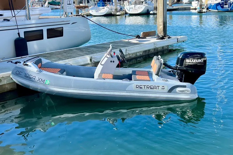 Slide: The Image of Inflatable boat with Suzuki motor docked at marina, near a Hylas H57 yacht, 2020 model. - 94