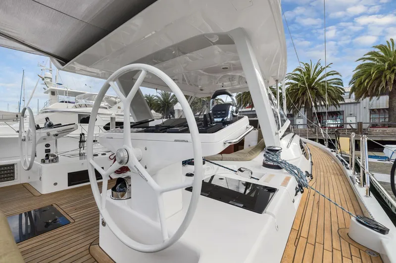 Slide: The Image of Luxury Hylas H57 yacht deck with dual steering wheels, docked at marina, 2020 model. - 40