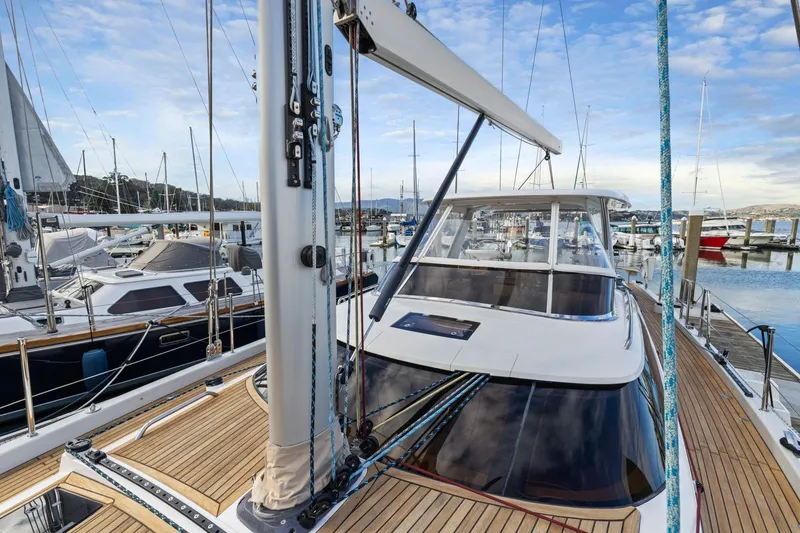 Slide: The Image of 2020 Hylas H57 yacht docked at marina, showcasing sleek design and wooden deck. - 51