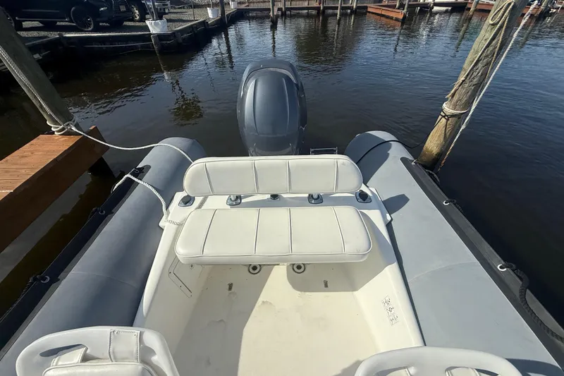 Slide: The Image of 2012 Zodiac Bayrunner Pro 650 boat docked, featuring seating and outboard motor. - 15
