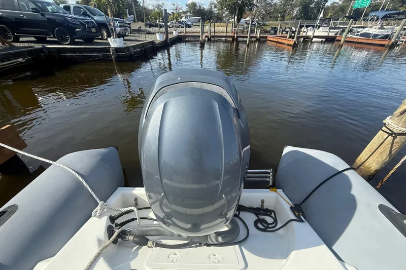 Slide: The Image of 2012 Zodiac Bayrunner Pro 650 boat docked with outboard motor, calm marina setting. - 18