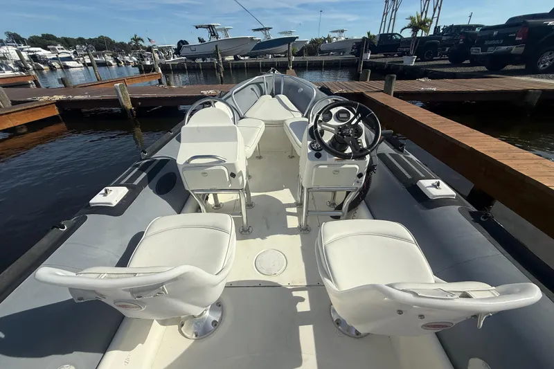 Slide: The Image of 2012 Zodiac Bayrunner Pro 650 boat interior with white seating at marina dock. - 7