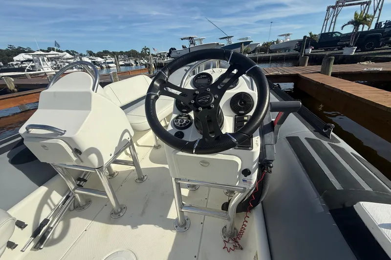 Slide: The Image of 2012 Zodiac Bayrunner Pro 650 boat interior with steering wheel and seating at marina. - 9