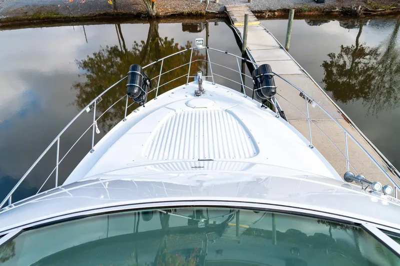 Slide: The Image of Bow view of 2000 Carver 450 Voyager Pilothouse docked by calm waters. - 30
